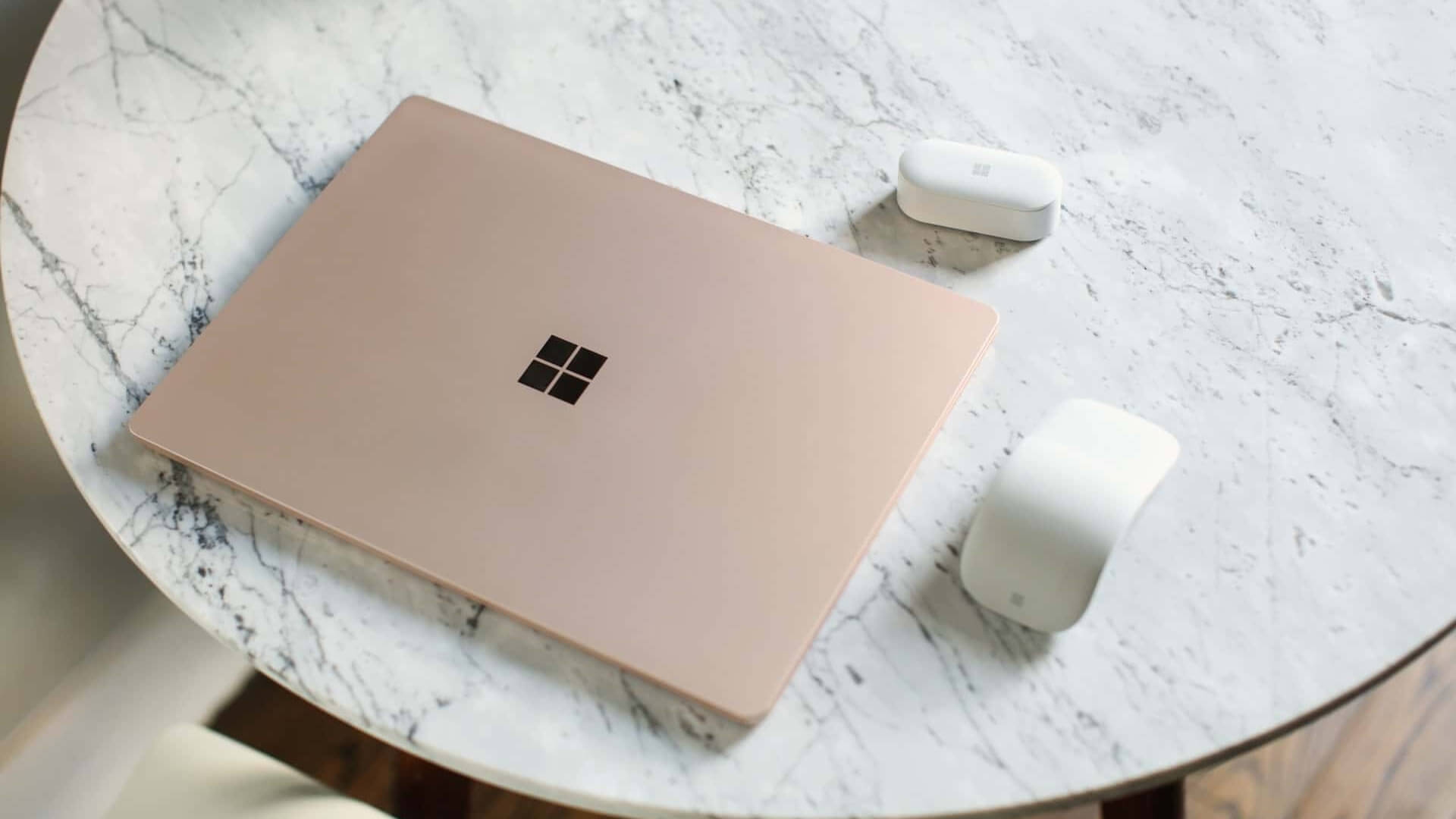 Closed laptop, next to a computer mouse, on a table.